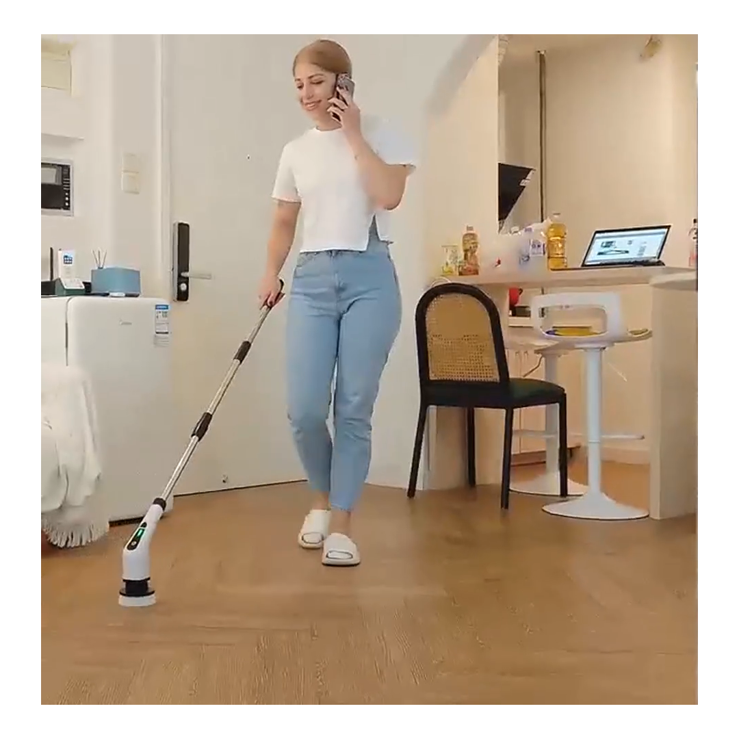 Person guiding the exact long-handle electric scrubber across a floor from a standing position